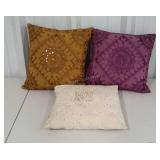 Three decorative throw pillows with beads and