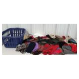 Laundry basket full of hats, scarves and gloves.
