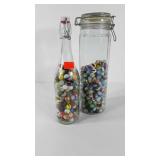 Marbles, glass canister and bottle partially full