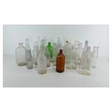 Group of glass bottles, some colored, sizes range