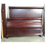 Queen size sleigh bed in cherry finish.
