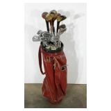 Golf bag with assorted older clubs and a few