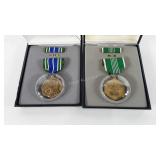 Two military merit medals with cases