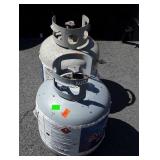 Two gas grill tanks, partially filled
