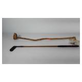 Two wood handled golf clubs, one natural wood Big