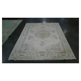 Cream colored area rug, pastel accents, 67" x