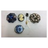 Three brooches, spartan stick pin, and a locket