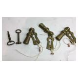 Three brass key holes and two keys