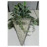 Large artificial plant in faux stone planter that