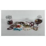 Two jars of beads and beaded bracelets