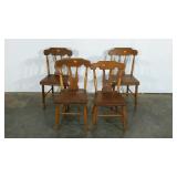 Four dining chairs, one appears to be slightly