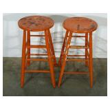 Two farm style stools with chippy orange paint.