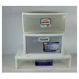 Three unmatched plastic storage drawers.