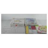 Two boxes of scrapbooking paper, stencils, and