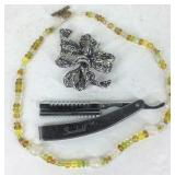 Brooch, beaded necklace, and straight razor