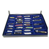 Collection of pocket knives in glass topped