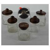 Six glass apothecary jars, five have wooden lids,