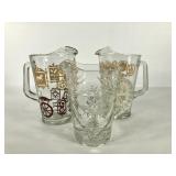 Three glass pitchers, two have painted designs