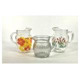 Three glass pitchers, two with painted designs