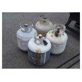 4 Propane Tanks 2 with some gas others empty,