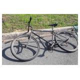 Black bicycle with 26in tires, chain is off,
