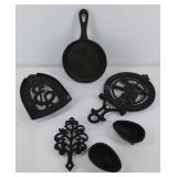 Group of cast iron trivets and more