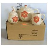 Three piece tea set with teapot, sugar, and