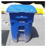 Blue trashcan with lid and artificial plants