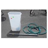 Plastic storage bin, water hose, and clothes