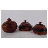 Decorative wooden carved jars with lids.