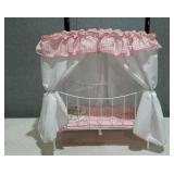 Child baby doll bed with pink and white frilly