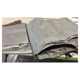 Storage tote with plastic tarps approx 6 tarps