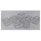 Seven glass canisters with lids, various sizes