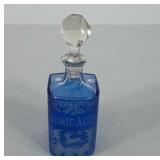 Glass bottle with blue etched design and marked