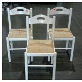 Three rush seat chairs, damage to one, seller