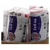 Four rolls of pink fiberglass insulation. Crate