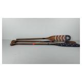 Three painted wooden paddles for decor use, one