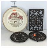 Strawberry pie plate and three cast trivets