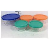 Five Pyrex storage bowls
