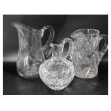 Three etched glass water pitchers, one marked