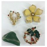 Three brooches and a polished gemstone