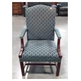 Green upholstered arm chair, has tears on