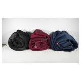 Three sleeping bags, two marked Coleman, one with