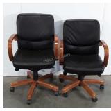 Two wooden and leather rolling office chairs,