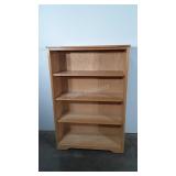 Wooden bookshelf, slightly off balance,