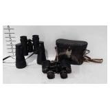 Two binoculars, one shows wear with damaged case