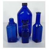 Four cobalt blue glass bottles