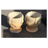 Two concrete flower pots, one has a large chip,