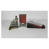 Three wooden houses, two are "My Home Town" and