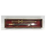 Sword and sheath in display case, stamped 440